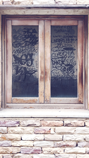 old and dusty window with finger writing on the glass, front view