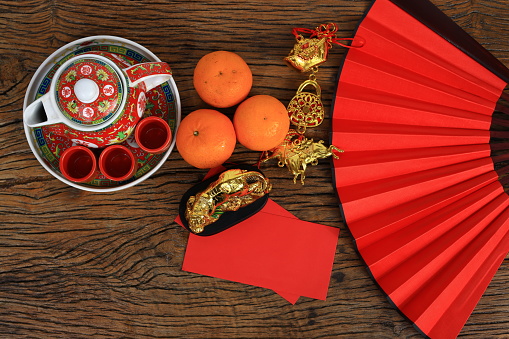 The Chinese hot tea set with orange fruit and a red envelope called AngPao and ornament accessories for Chinese New Yea