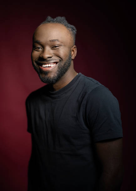 istock Smiling young African man looking at camera on red background 1995390472