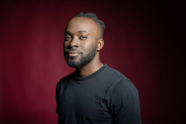 istock Handsome African man wearing black shirt on red background 1995390999