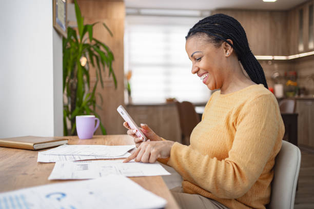 istock Smiling black woman doing home finances at home 1995403110
