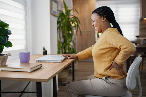 istock Black woman experiencing back pain while working at home 1995403617