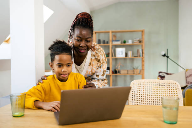 istock Cute boy using laptop and showing to grandma 1995414187