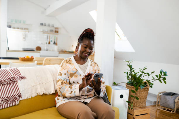 istock Happy African woman using smartphone at home 1995414197