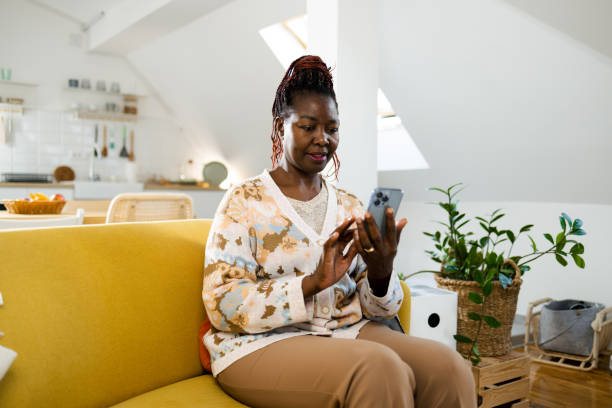 istock African American woman using smartphone at home 1995414208