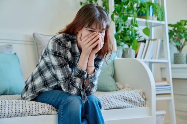 istock Upset sad young female sitting on couch at home 1995419118