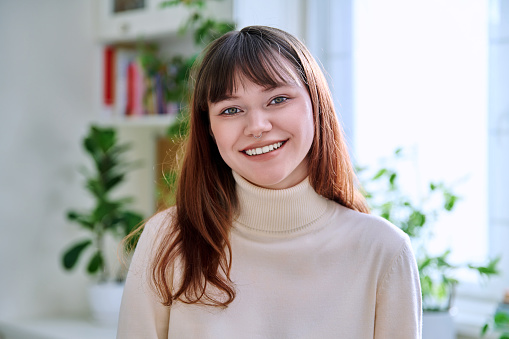 Portrait of a beautiful smiling happy young female 18-20 years old. Fashionable modern college student with nose piercing looking at camera. Youth, beauty, fashion, lifestyle concept