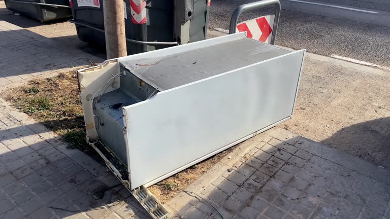 Abandoned refrigerator lying down on the sidewalk