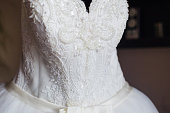 Close-up of a white wedding dress with embroidery and beads.
