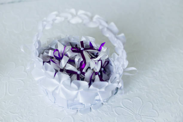 Violet bows for guests in a white basket. wedding. top view.