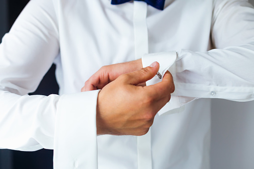 close up of a hand groom how wears white shirt and cufflink.