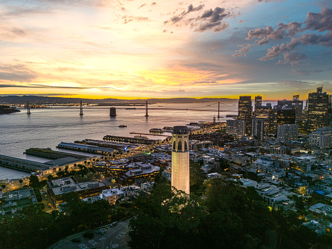 Aerial view Coit Tower and the Bay Bridge at sunrise on a clear morning.