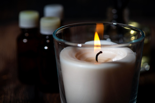 burning aroma candle on a dark wooden background, closeup