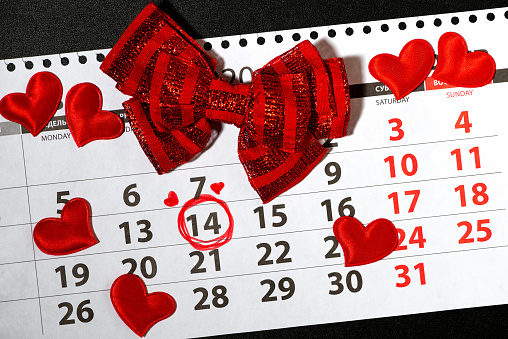 February 14 on a calendar sheet, red hearts, holiday attributes, closeup