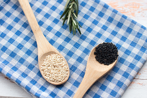 sesame seeds in a bowl on a wooden background. Seasoning for cooking