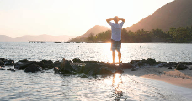 istock Mature man explores beach at sunrise 1995599989