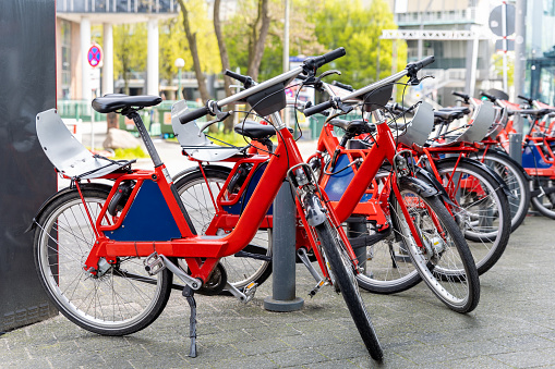 Closeup view many red city bikes parked in row at german Hamburg city street rental parking sharing station or sale. Healthy ecology urban transportation. Sport environmental transport infrastructure.