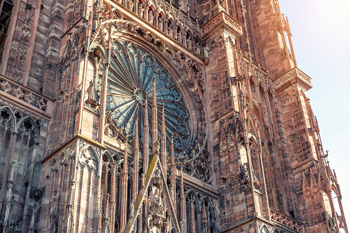 Close-up view of Cathedrale Notre Dame de Strasbourg in France Strasbourg city. Detail gothic architecture rose window stained glass facade wall of medieval historic church Alsace town sunny sky day