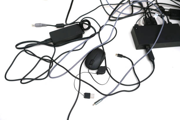 messy electrical wires of electronics equipments on white background