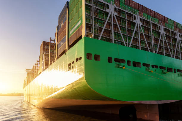 istock Scenic view giant cargo container ship loading Hamburg city port harbour against seaport cranes warm evening sunset lights. Global commercial trade freight charter shipping and logistics background 1995647736