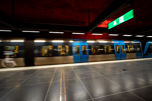 Motion blur of subway train moving past platform in dark