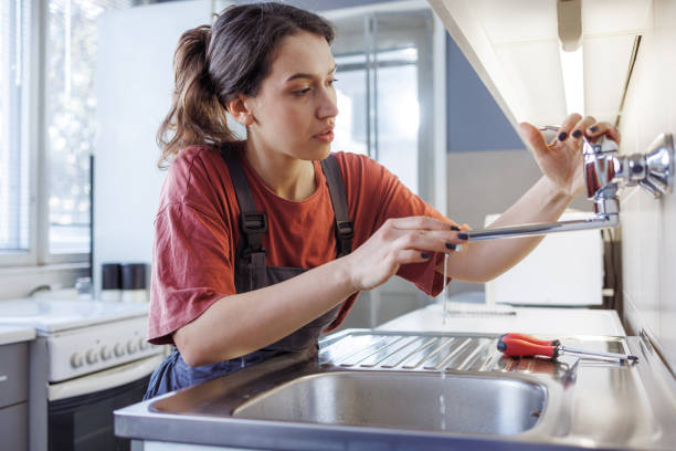 istock A woman fixing a new tap and kitchen sink 1995671695