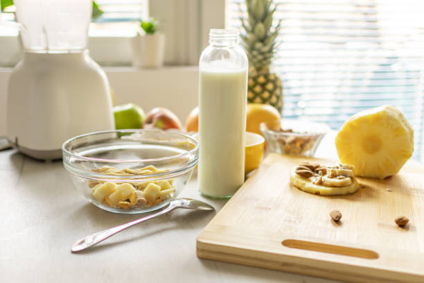 Healthy ingredients for tasty breakfast. Pineapple, cereal, oatmeal, corn flakes, grapefruit, apple and milk.