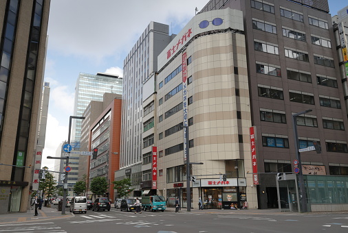 Sapporo, Japan - May 30, 2023: Street level view of intersection on Kita 2Jo-Dori at Sapporoekimae-Dori  on a spring afternoon. Clouds over Hokkaido Prefecture.