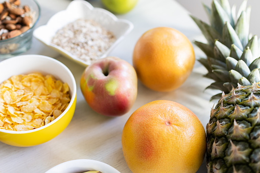 Healthy ingredients for tasty breakfast. Pineapple, cereal, corn flakes, grapefruit, apple.