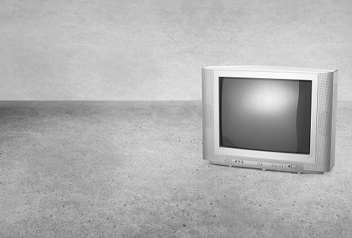 Retro old style tube tv on a cement concrete background
