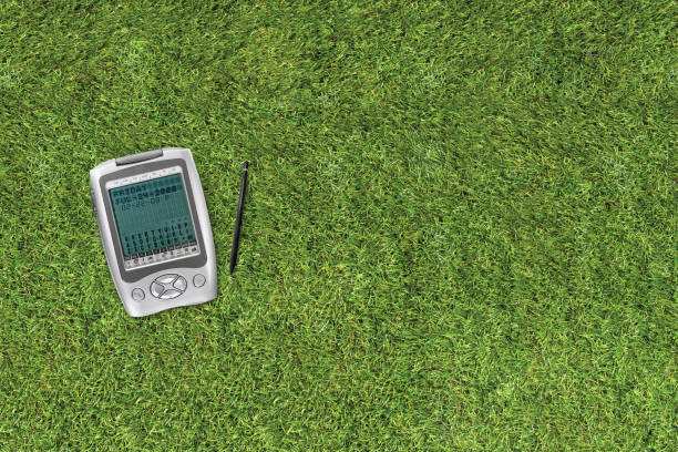 Old retro digital assistant and translator with a pen on a grass background