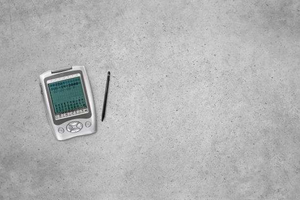 Old retro digital assistant and translator with a pen on a concrete cement background