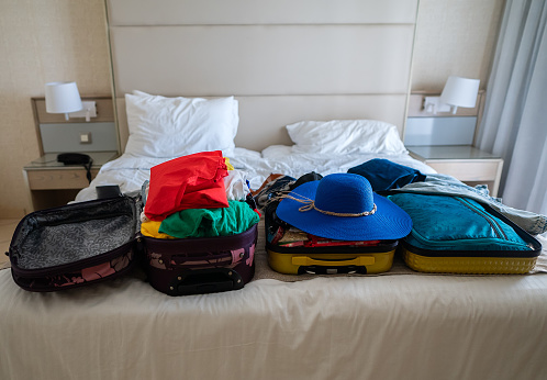 Suitcase with clothes on the bed. Preparing for vacation.
