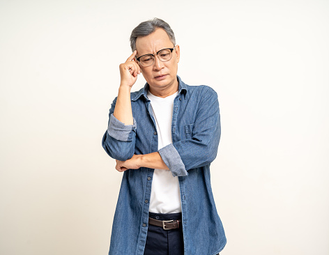 Handsome asian mature old man standing serious thinking on isolated white background. Portrait of serious depressed senior asian man looking at camera. Mature People and lifestyle