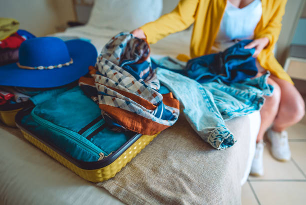 istock Woman packs her clothes into a suitcase. Preparing for vacation. 1995803324