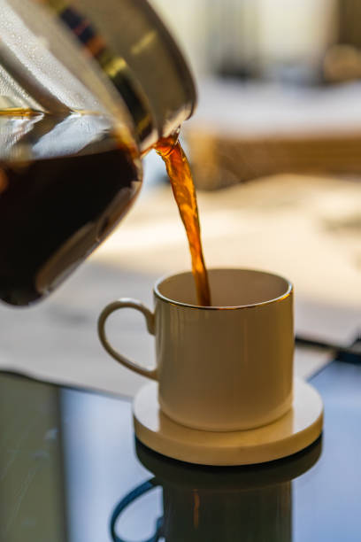 istock Close up view of pouring hot coffee into a cup. 1995822330