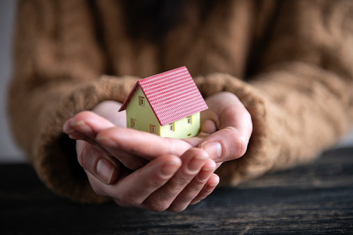 Woman's Hands Holding a Little House
