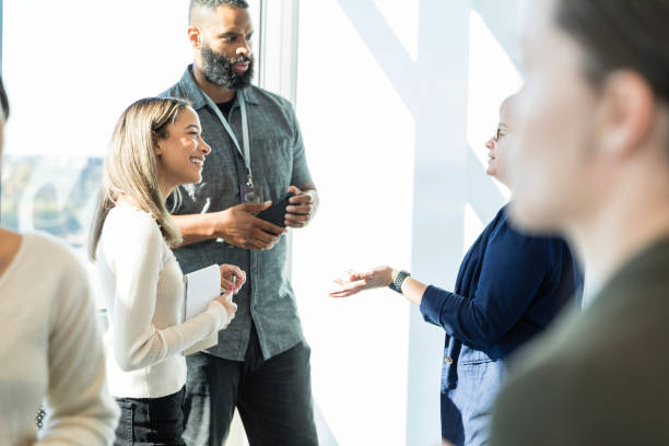 istock Two business people listen to unrecognizable marketing executive 1995828639