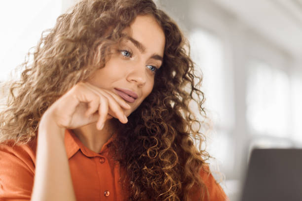 istock Pensive woman with laptop in a modern office 1995838192