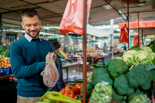 Man Shopping at the Farmer's Market. One Man Buying a Fresh Vegetable at a Community Marketplace.