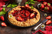 An open strawberry pie in close-up on a dark background