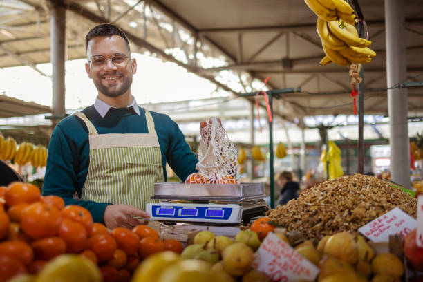 istock Man Looking at Camera While Working on Stall at Farmer's Market 1995860774