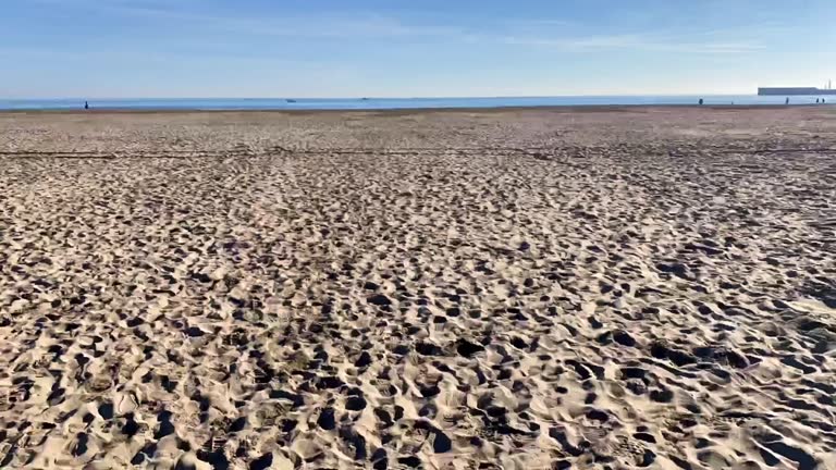 Walking over wooden deck on the sand time lapse