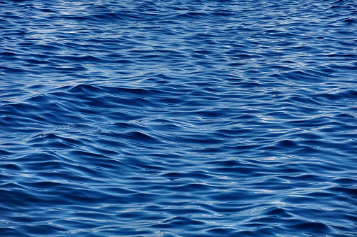 Wavy surface with rippled waves and light reflection on the top