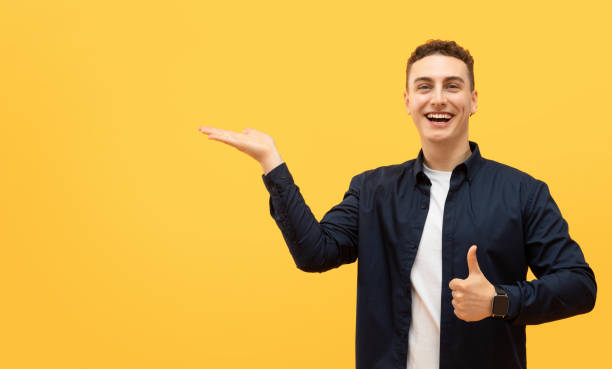istock Excited young guy showing something on his palm 1995890096