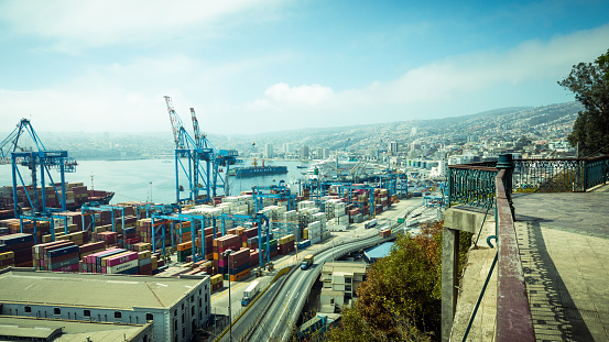 The container port of Valparaiso with its large blue cranes and the many colorful containers on the coast of Chile