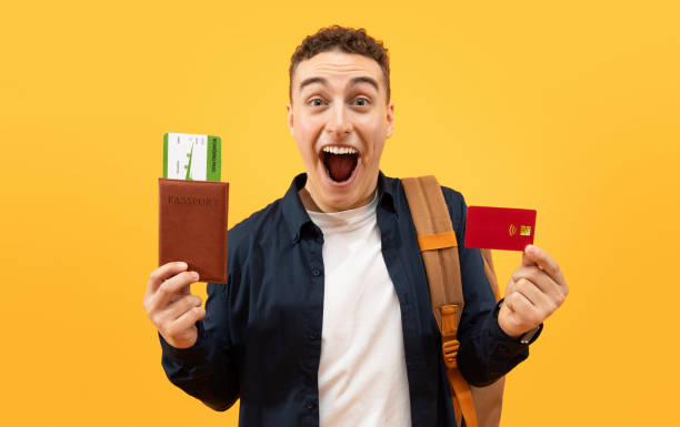 istock Happy guy student showing credit card and passport 1995891725