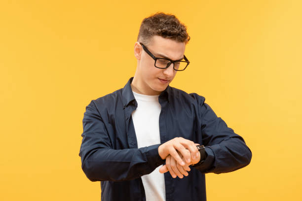 istock Smiling happy young handsome man looking at his watch 1995891733