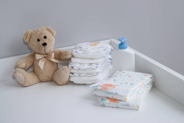 istock A stack of diapers, teddy bear and baby supplies on changing table 1995892310