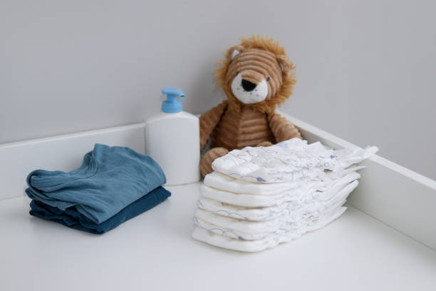 istock A stack of diapers, blue onesies, plush lion and baby supplies on changing table 1995893218